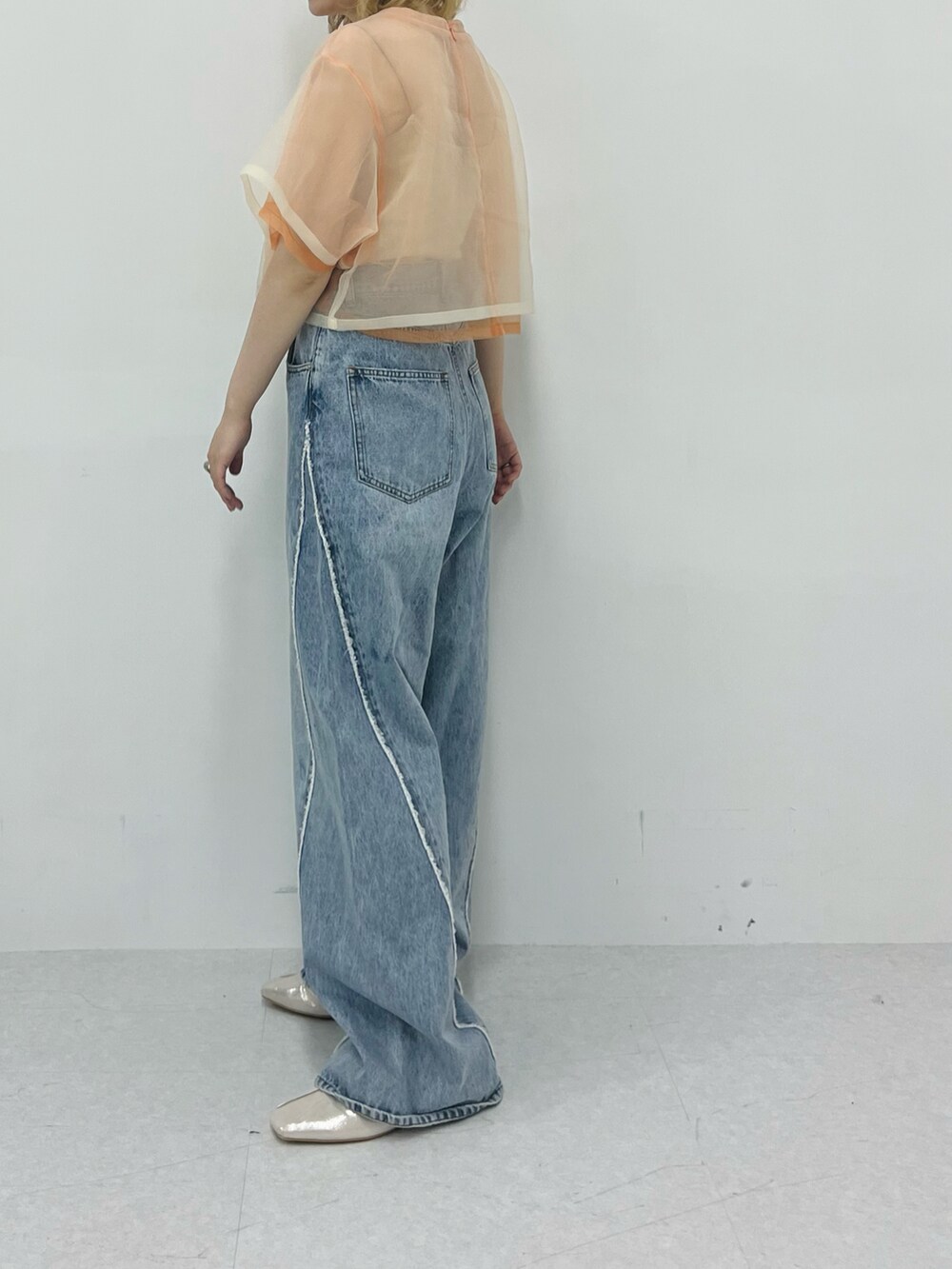 オレンジ系のTシャツ/カットソー、ブルー系のデニムパンツを着用したレディースの春コーディネートの3枚目の写真