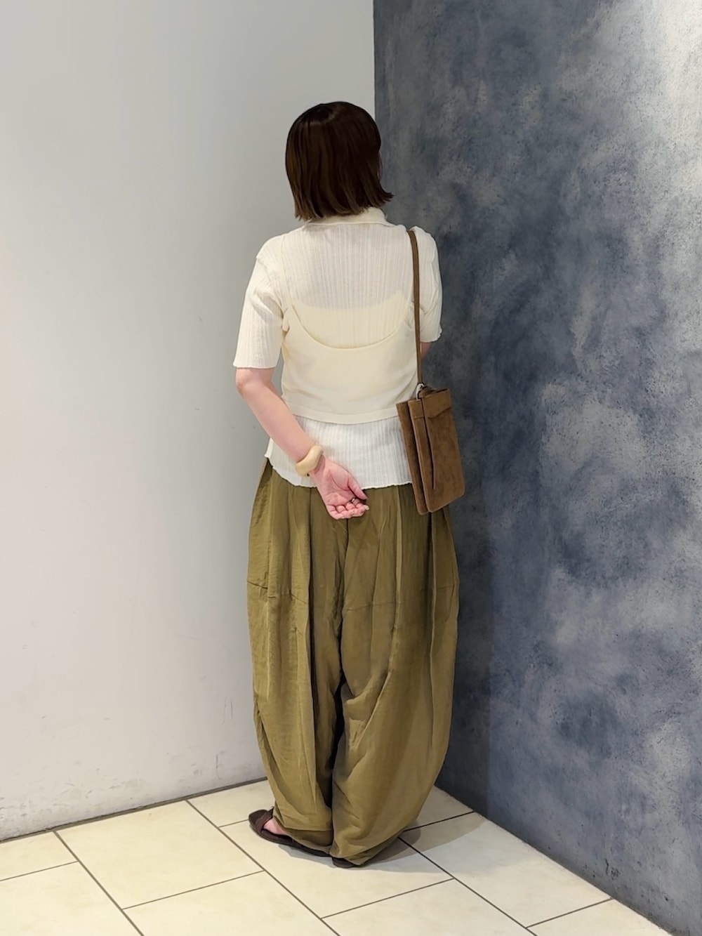 ホワイト系のニット/セーター、グリーン系のその他パンツ、ブラウン系のサンダルを着用したレディースの夏コーディネートの3枚目の写真
