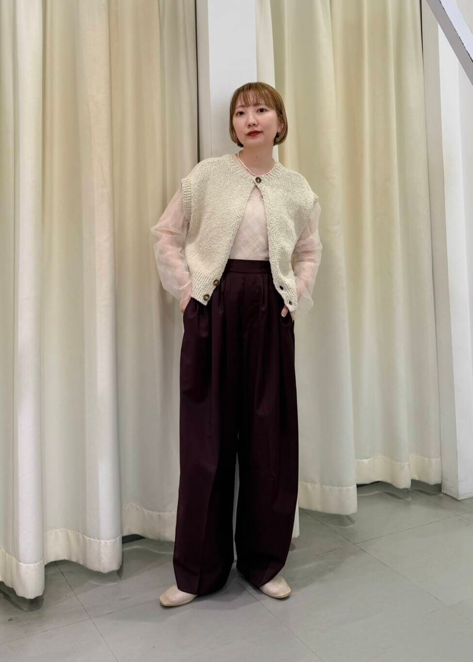 レッド系のその他パンツ、ベージュ系のニット/セーター、ホワイト系のTシャツ/カットソーを着用したレディースの春コーディネートの3枚目の写真