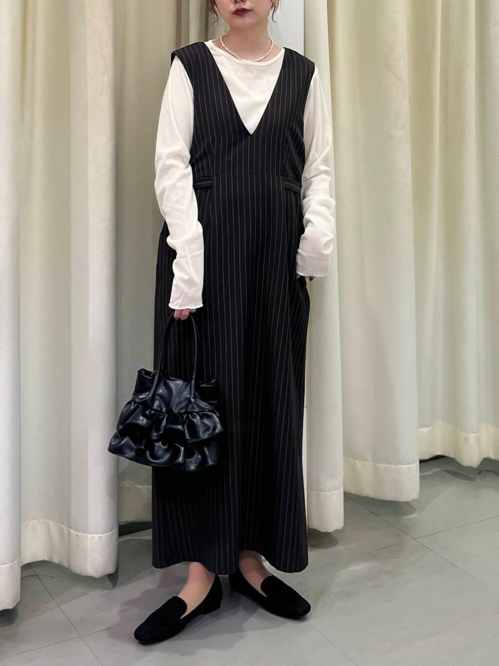 ブラック系のローファー、ブラック系のハンドバッグ、ホワイト系のTシャツ/カットソーを着用したレディースの春コーディネートの2枚目の写真