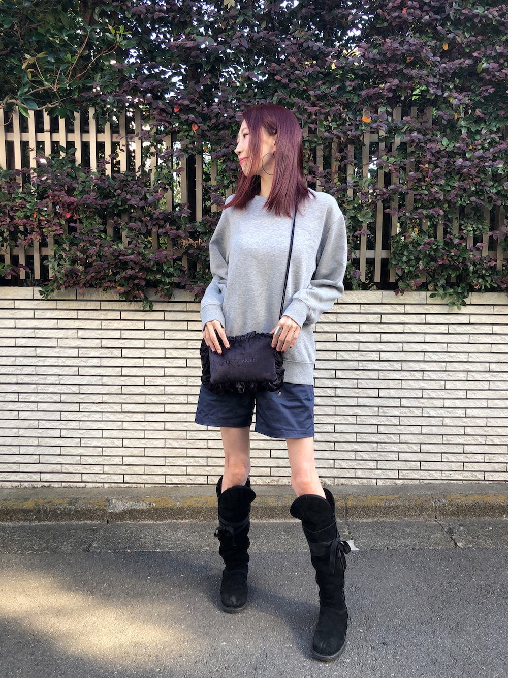 グレー系のスウェット、ブルー系のパンツ、ブラック系のブーツを着用したレディースの冬コーディネートの2枚目の写真