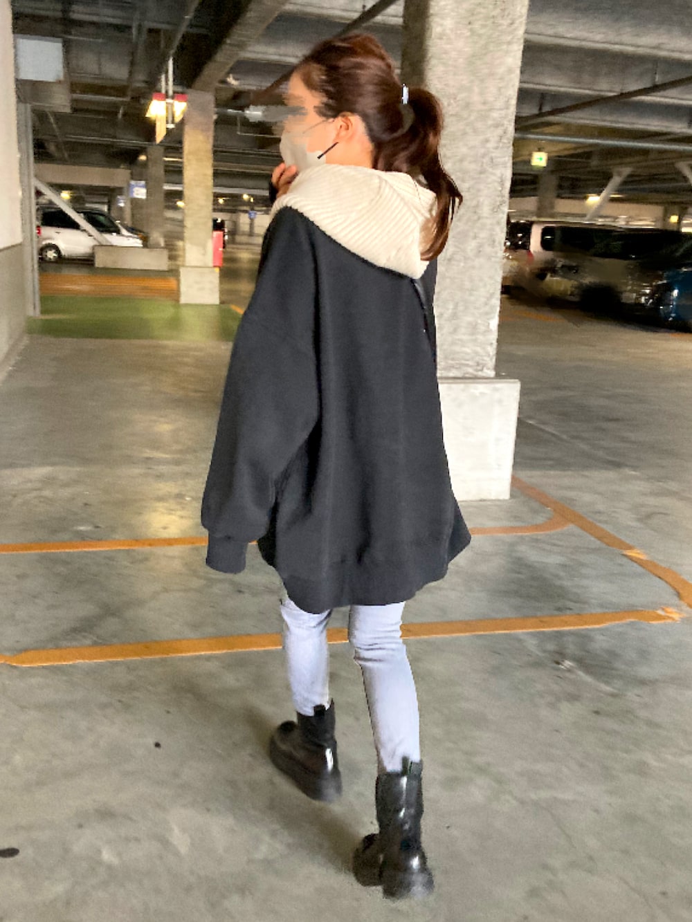 グレー系のデニムパンツ、ブラック系のブーツ、ブラック系のショルダーバッグを着用したレディースの冬コーディネートの2枚目の写真