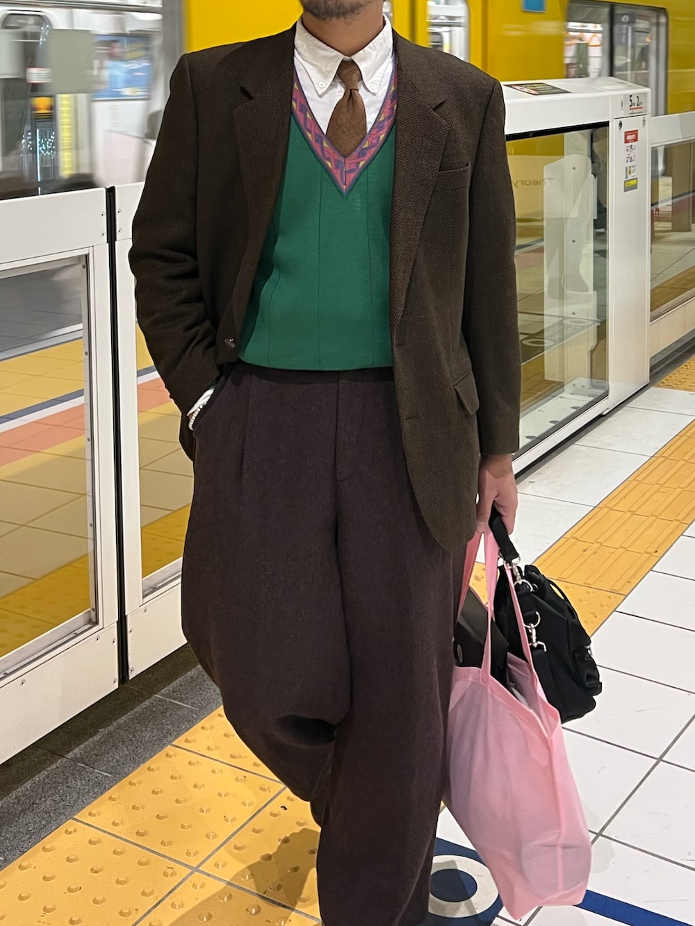 ブラウン系のテーラードジャケット、グリーン系のニット/セーター、ブラウン系のその他パンツを着用したメンズの冬コーディネートの2枚目の写真