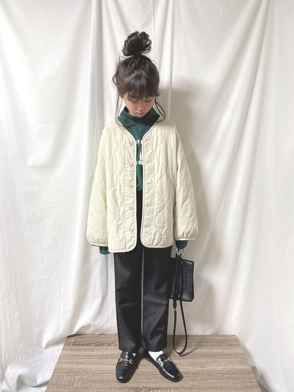 ホワイト系のブルゾン、ブラック系のスラックス、ブラック系のローファーを着用したキッズの冬コーディネートの3枚目の写真