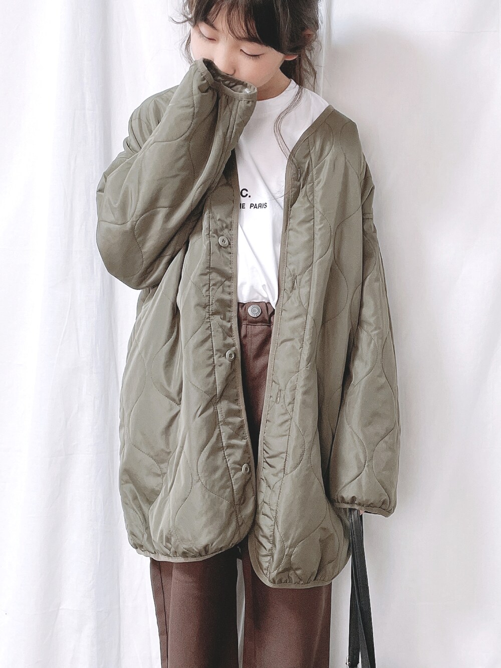 グリーン系のモッズコート、ブラウン系のその他パンツ、ホワイト系のTシャツ/カットソーを着用したキッズの秋コーディネートの2枚目の写真