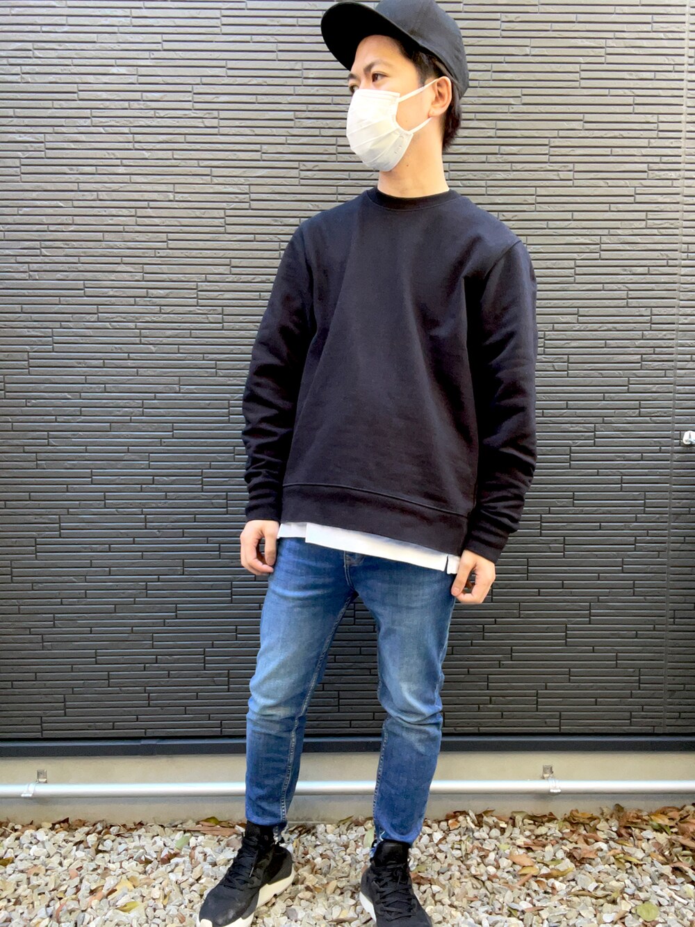 ブラック系のスウェット、ホワイト系のTシャツ/カットソー、ブルー系のデニムパンツを着用したメンズの冬コーディネートの2枚目の写真