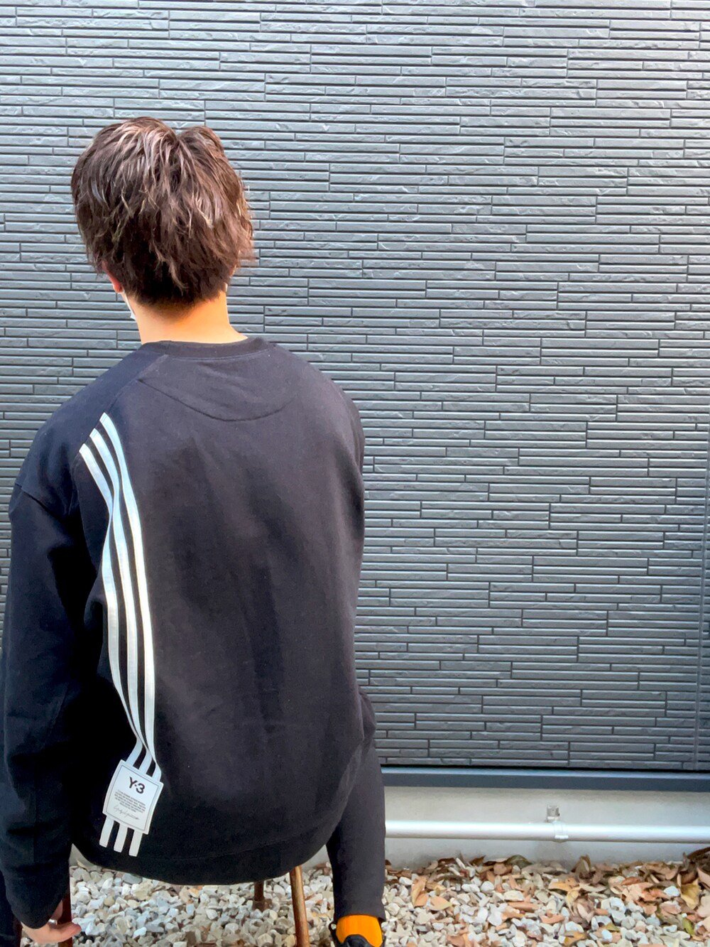 ブラック系のスウェット、ブラック系のスラックス、ブラック系のスニーカーを着用したメンズの冬コーディネートの2枚目の写真