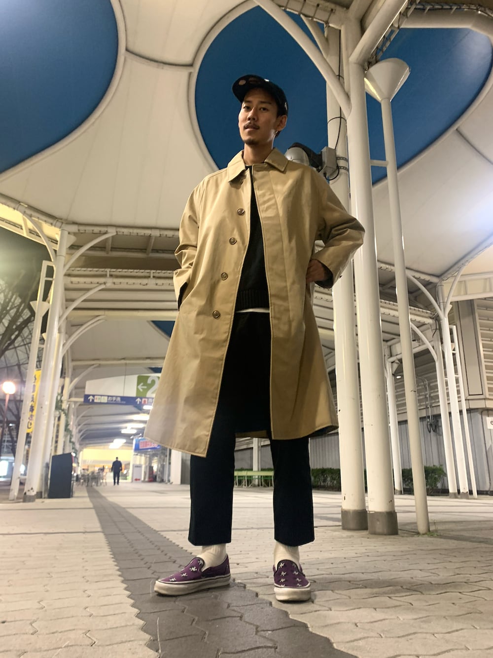 ブラック系のスラックス、ブラック系のニット/セーター、ベージュ系のトレンチコートを着用したメンズの秋コーディネートの3枚目の写真