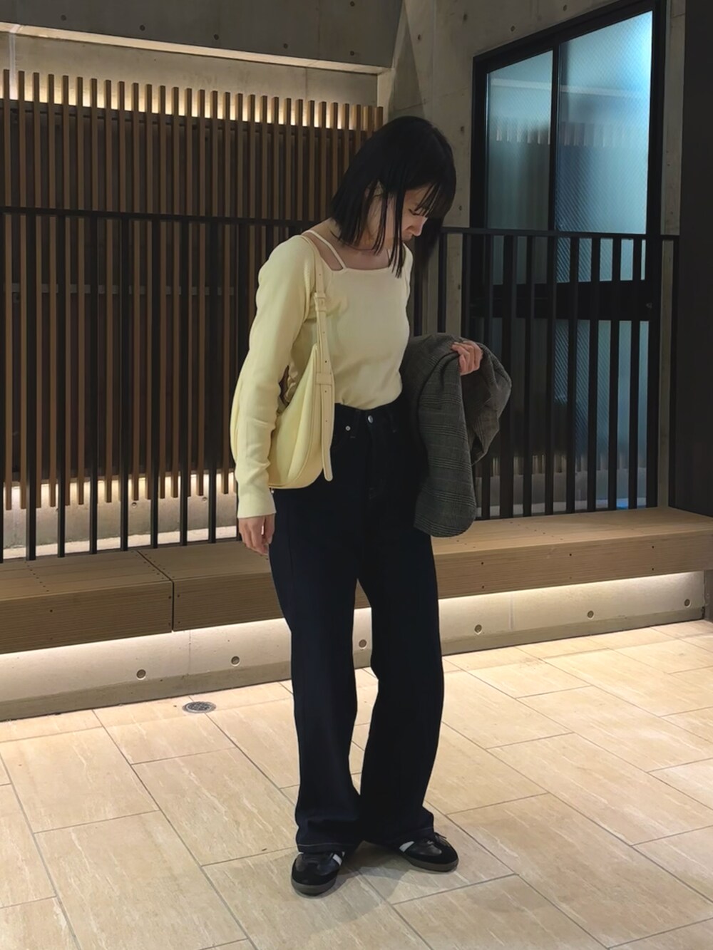 ホワイト系のニット/セーター、グレー系のジャケット/アウター、ブルー系のデニムパンツを着用したレディースの春コーディネートの2枚目の写真