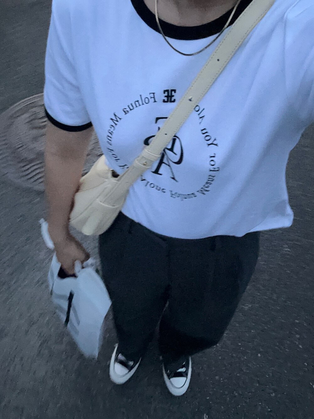 グレー系のスラックス、ブラック系のスニーカー、イエロー系のハンドバッグを着用したレディースの夏コーディネートの2枚目の写真