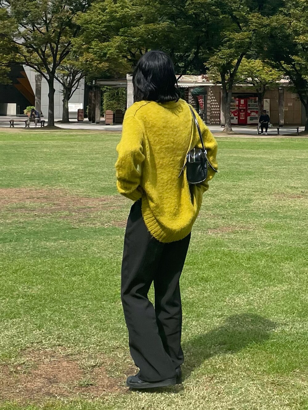 ブラック系のスラックス、ブラック系のスニーカーを着用したレディースの秋コーディネートの2枚目の写真