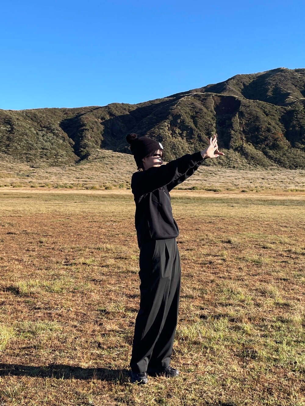 ブラック系のスラックス、ブラック系のショルダーバッグ、ブラック系のスウェットを着用したレディースの秋コーディネートの2枚目の写真