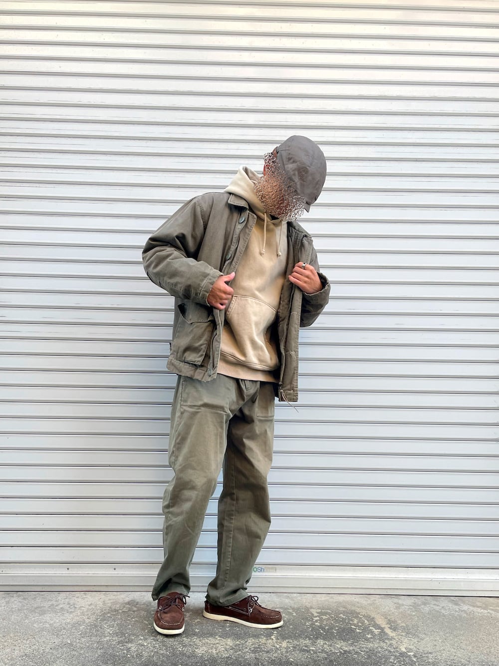 グリーン系のカーゴパンツ、ブラウン系のローファー、ベージュ系のパーカーを着用したメンズの秋コーディネートの2枚目の写真
