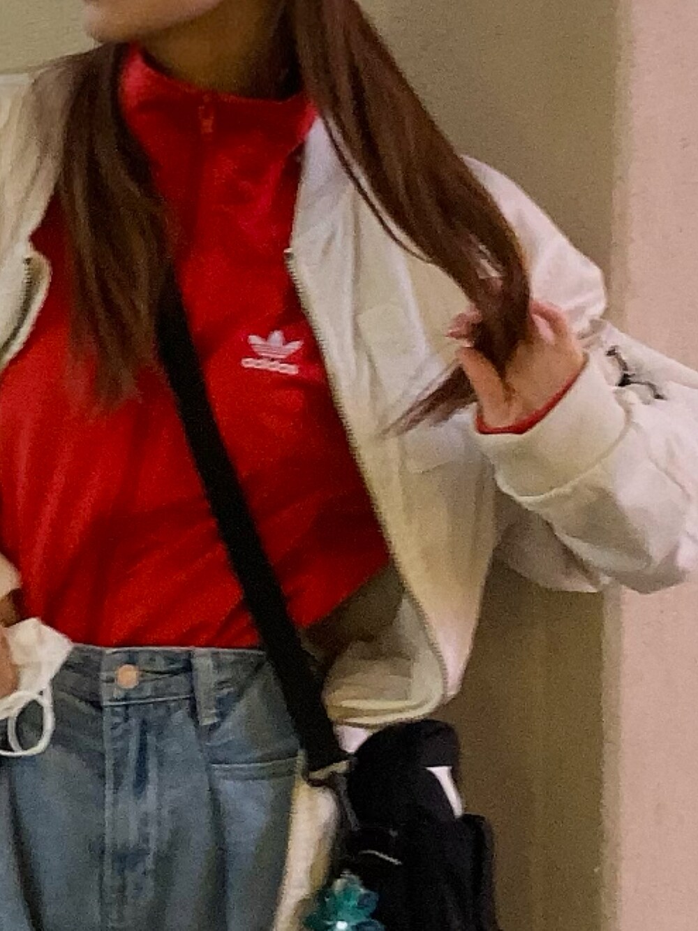 レッド系のジャージ、ホワイト系のスニーカー、グレー系のニットキャップ/ビーニーを着用したレディースの春コーディネートの2枚目の写真