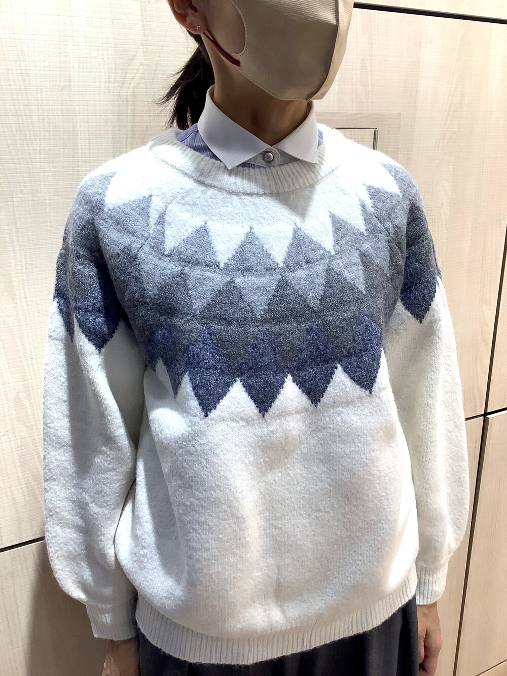 ブルー系のビジネスシャツ、ホワイト系のニット/セーターを着用したレディースの秋コーディネートの2枚目の写真