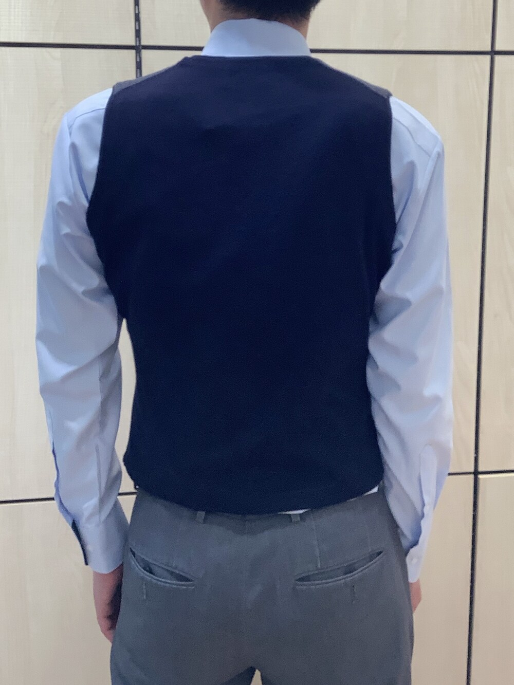 ブルー系のビジネスシャツ、ブルー系のベスト、グリーン系のネクタイを着用したメンズの秋コーディネートの3枚目の写真