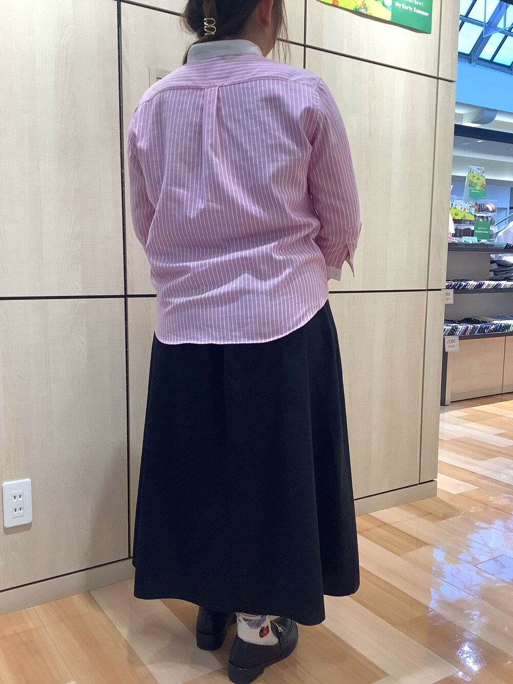 ピンク系のシャツ/ブラウス、ブラック系のスカートを着用したレディースの夏コーディネートの2枚目の写真