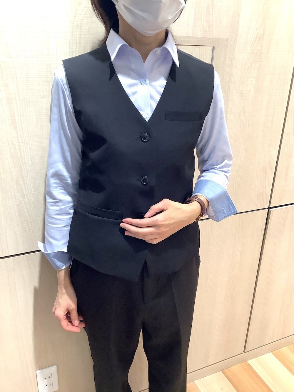 ブラック系のベスト、ブルー系のビジネスシャツを着用したレディースの冬コーディネートの2枚目の写真