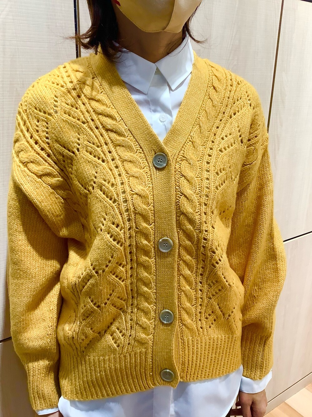 イエロー系のカーディガン/ボレロ、ホワイト系のシャツ/ブラウスを着用したレディースの秋コーディネートの2枚目の写真