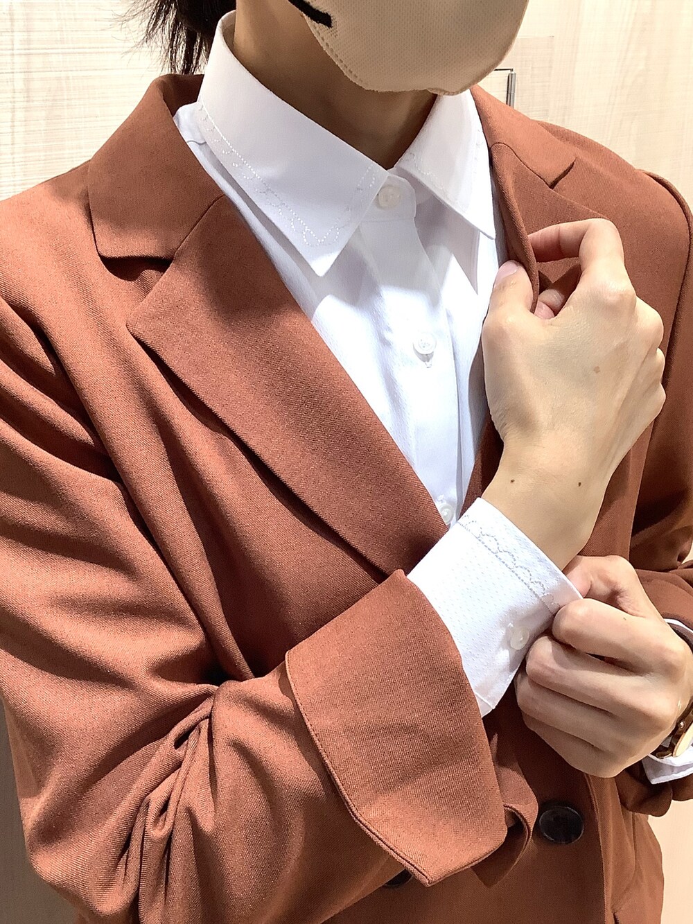 ブラウン系のテーラードジャケット、ホワイト系のビジネスシャツ、ベージュ系のスニーカーを着用したレディースの秋コーディネートの2枚目の写真