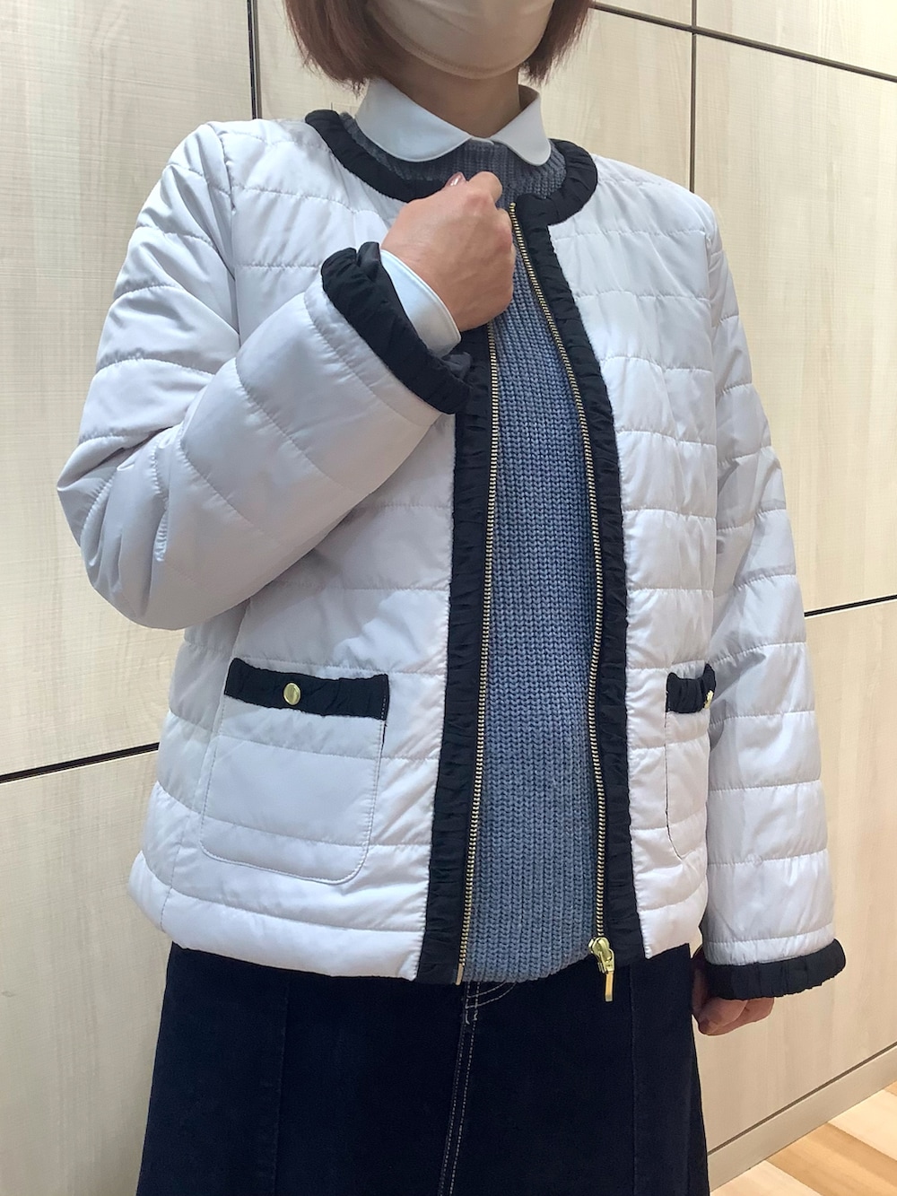 ホワイト系のシャツ/ブラウス、グレー系のベスト、ホワイト系のブルゾンを着用したレディースの冬コーディネートの2枚目の写真
