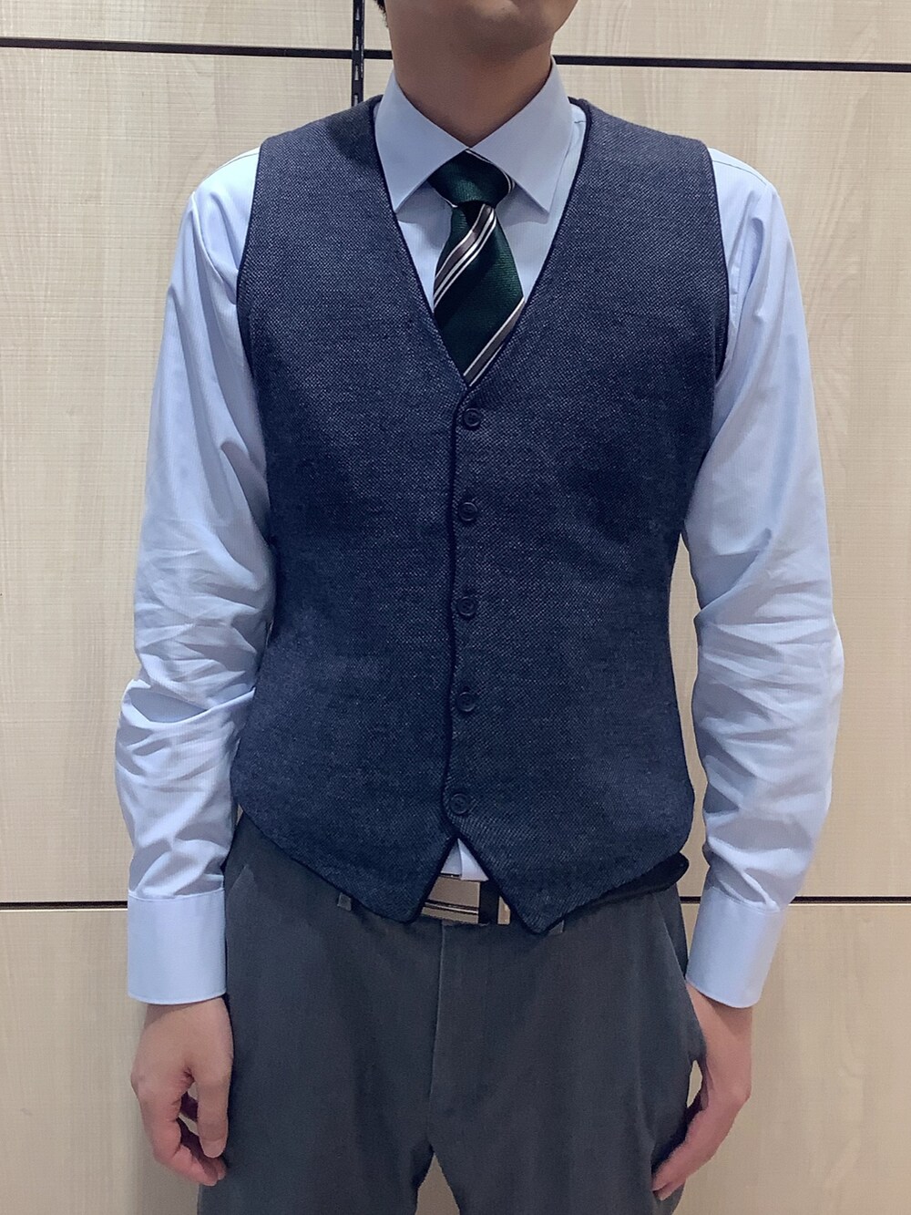 ブルー系のビジネスシャツ、ブルー系のベスト、グリーン系のネクタイを着用したメンズの秋コーディネートの2枚目の写真