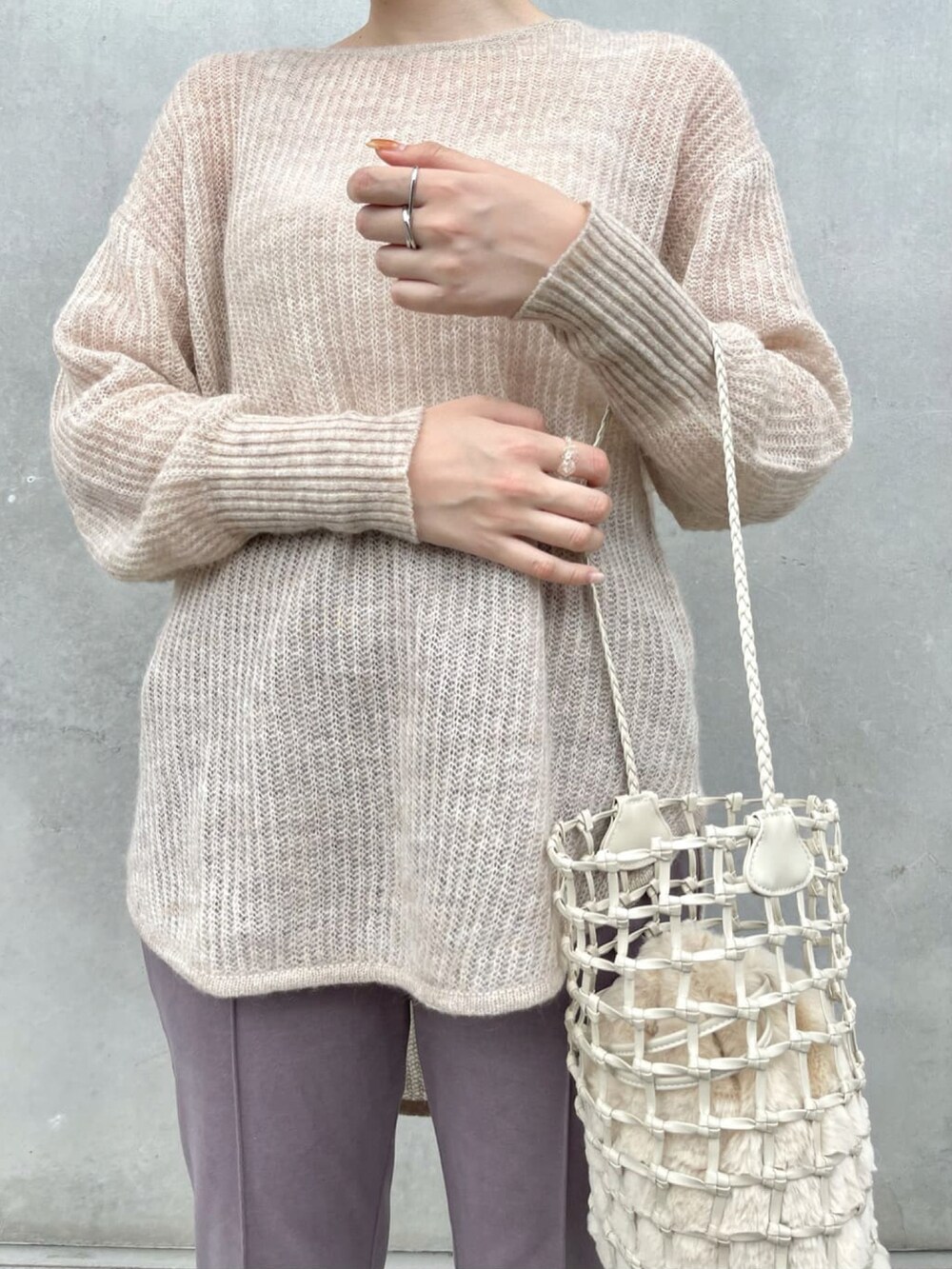 ベージュ系のニット/セーター、ホワイト系のショルダーバッグ、パープル系のスラックスを着用したレディースの春コーディネートの3枚目の写真