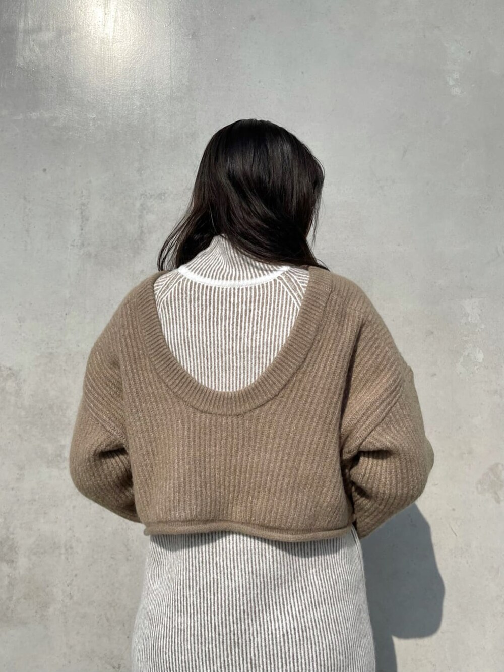 ベージュ系のワンピース、ベージュ系のニット/セーター、ホワイト系のブーツを着用したレディースの冬コーディネートの3枚目の写真