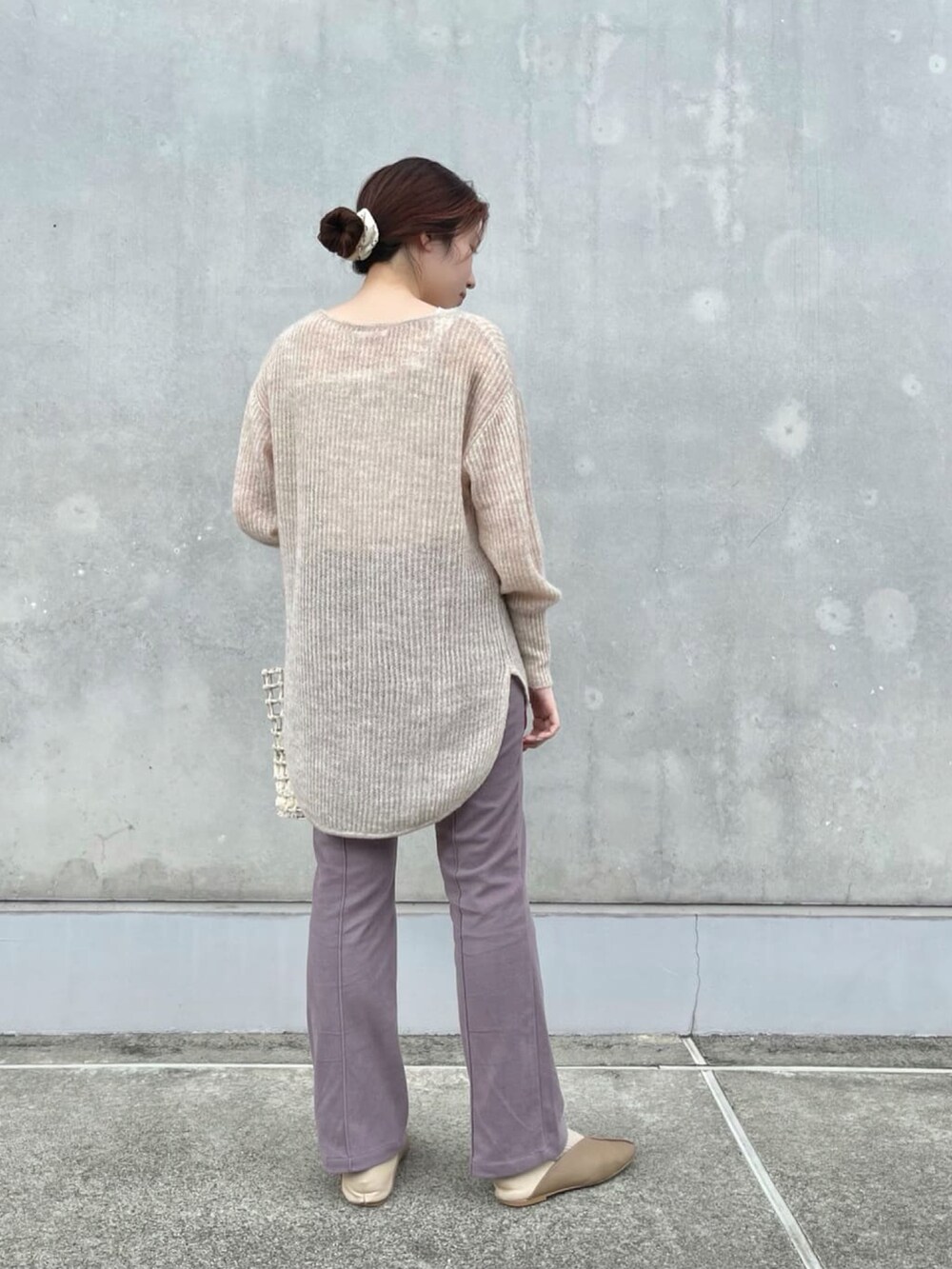 ベージュ系のニット/セーター、ホワイト系のショルダーバッグ、パープル系のスラックスを着用したレディースの春コーディネートの2枚目の写真