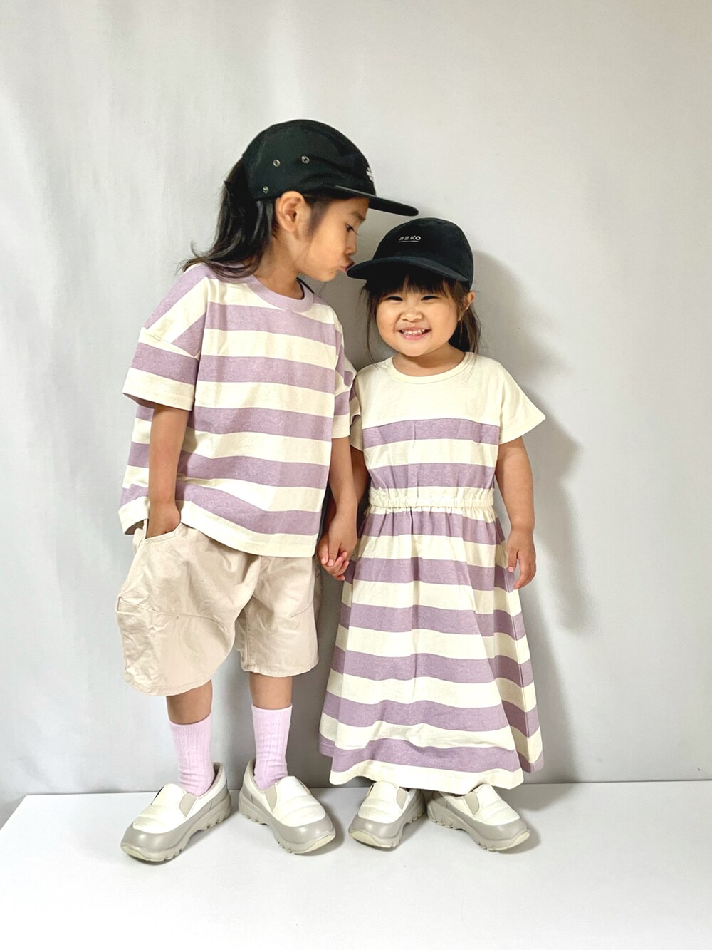 パープル系のTシャツ/カットソー、パープル系のワンピース、ホワイト系のシューズを着用したキッズの夏コーディネートの3枚目の写真