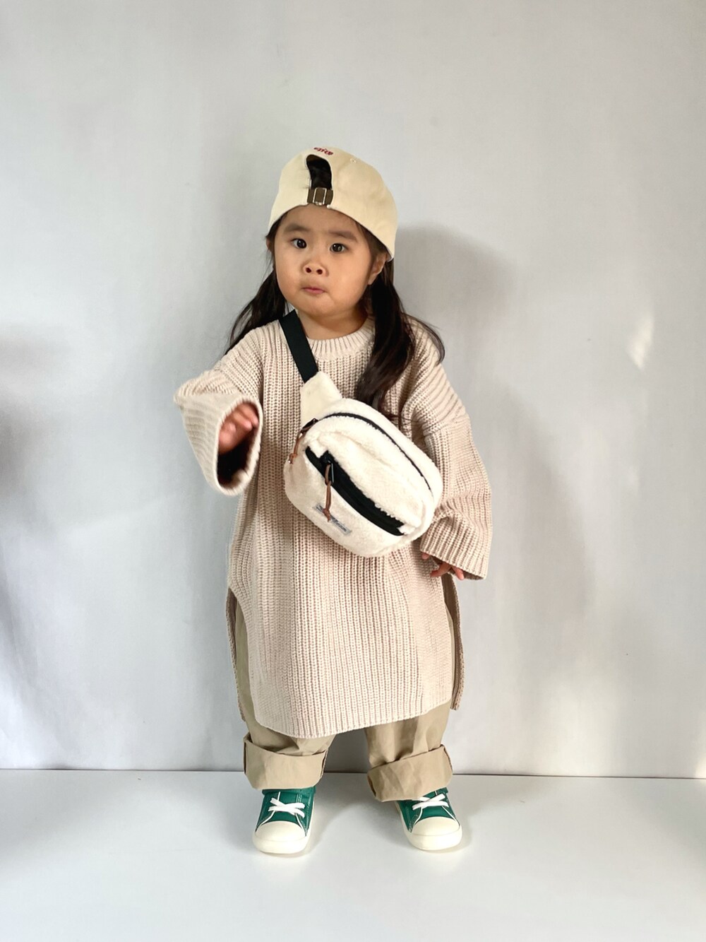 グリーン系のスニーカー、ベージュ系のその他パンツ、ホワイト系のボディバッグ/ウエストポーチを着用したキッズの冬コーディネートの4枚目の写真