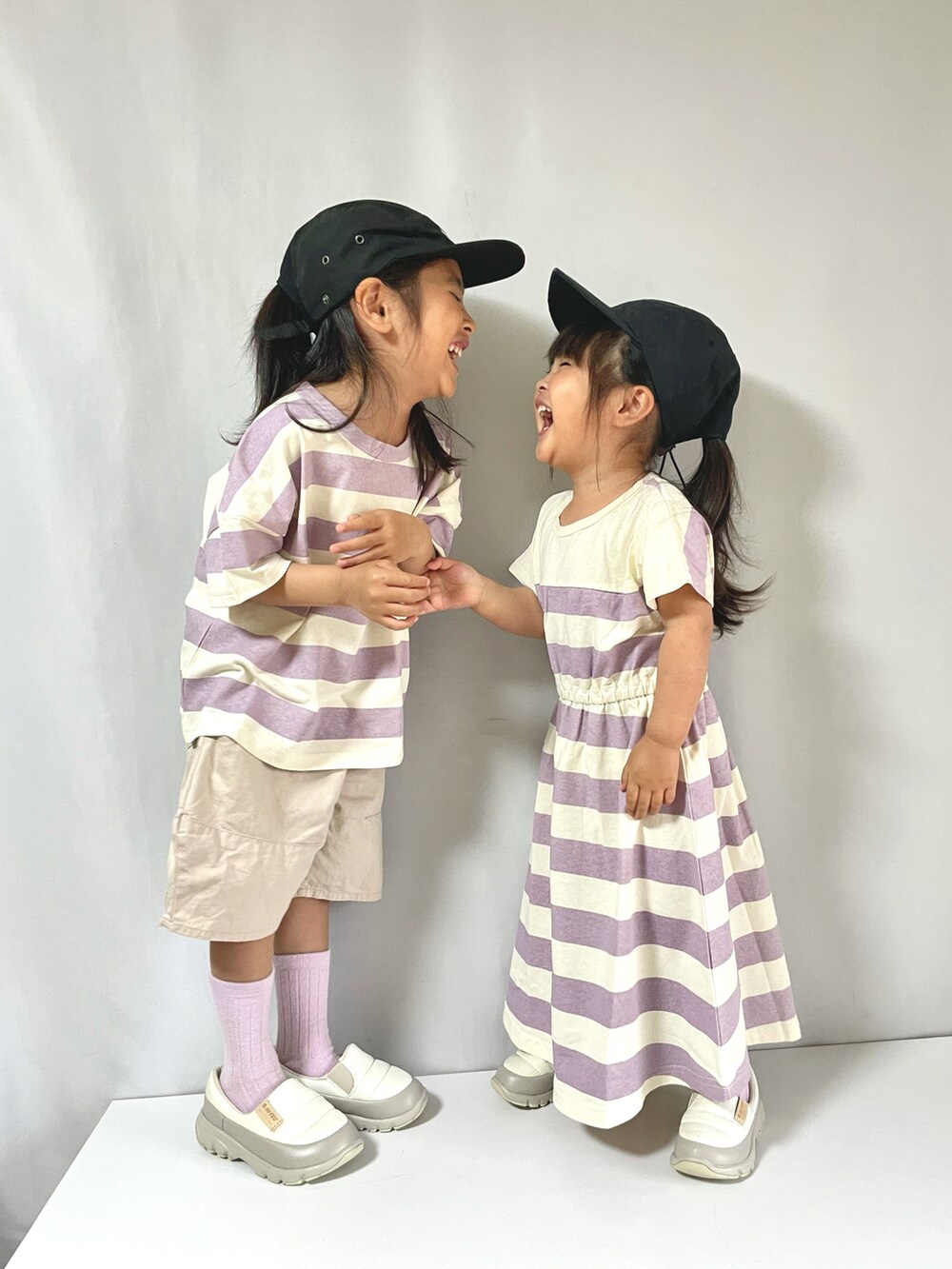 パープル系のTシャツ/カットソー、パープル系のワンピース、ホワイト系のシューズを着用したキッズの夏コーディネートの4枚目の写真
