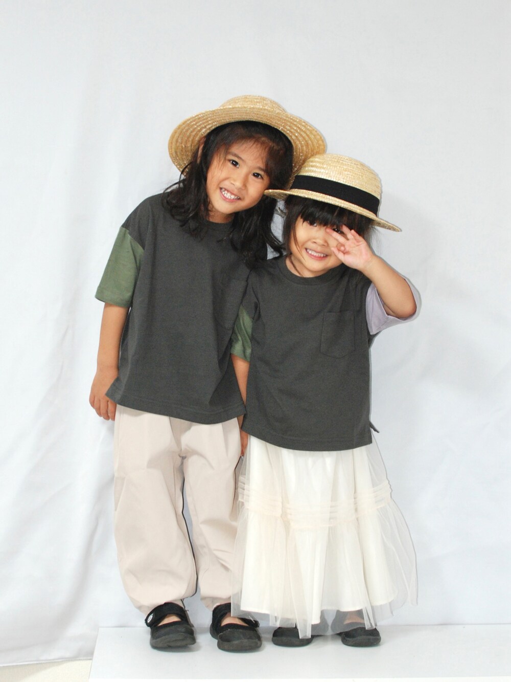 ブラック系のTシャツ/カットソー、ベージュ系のスラックス、ホワイト系のスカートを着用したキッズの夏コーディネートの4枚目の写真