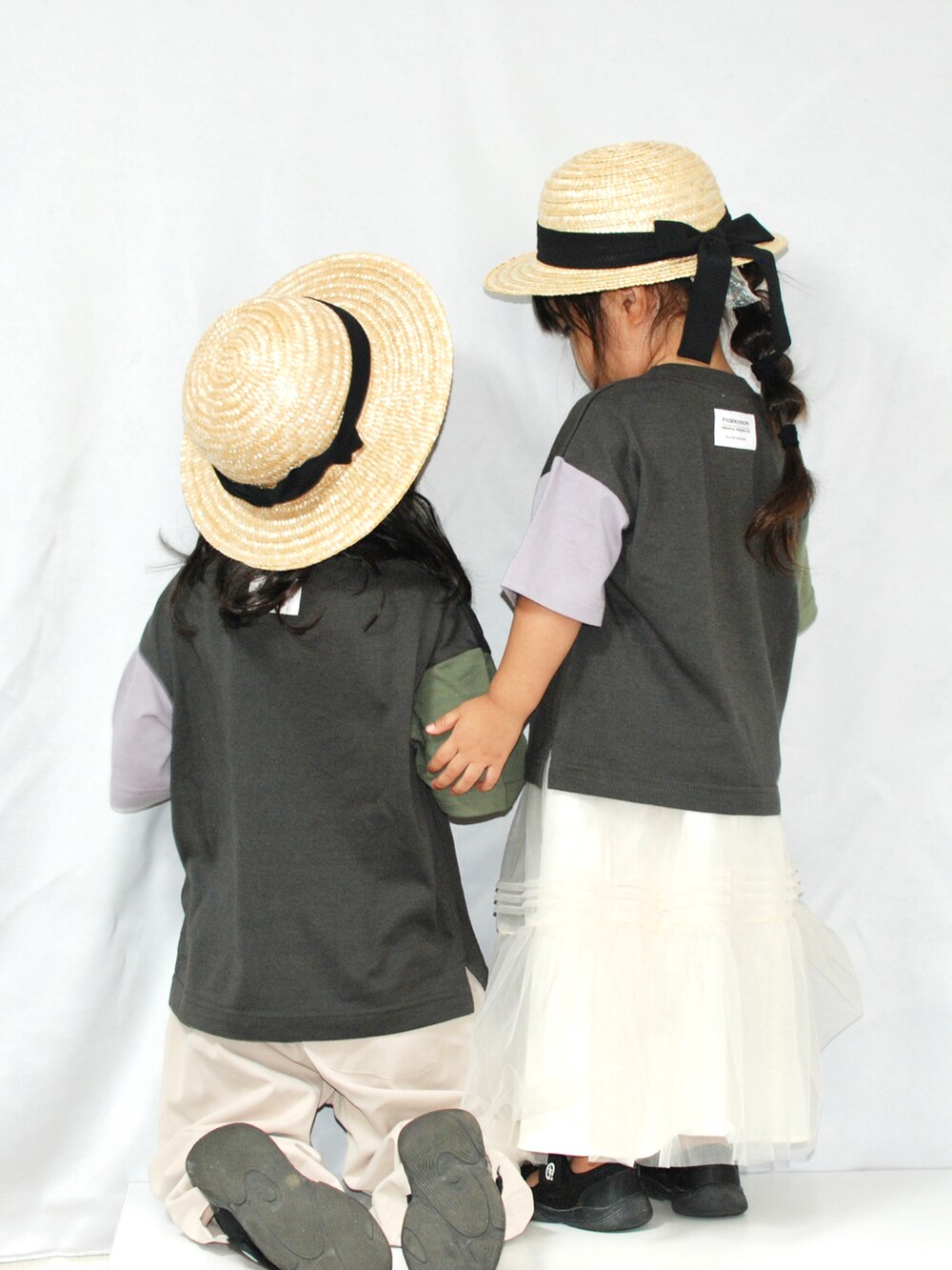 ブラック系のTシャツ/カットソー、ベージュ系のスラックス、ホワイト系のスカートを着用したキッズの夏コーディネートの3枚目の写真