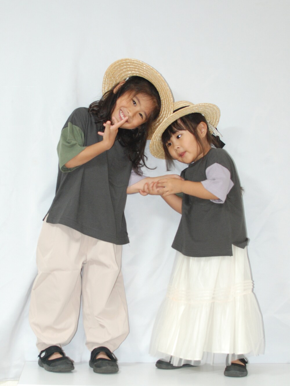 ブラック系のTシャツ/カットソー、ベージュ系のスラックス、ホワイト系のスカートを着用したキッズの夏コーディネートの5枚目の写真