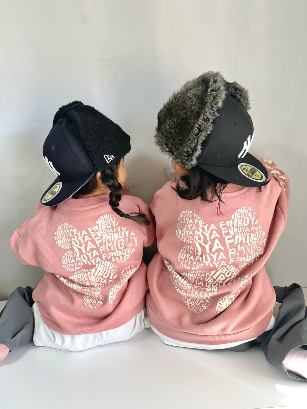 グレー系のスラックス、ピンク系のスウェット、ブラック系のキャップを着用したキッズの冬コーディネートの5枚目の写真