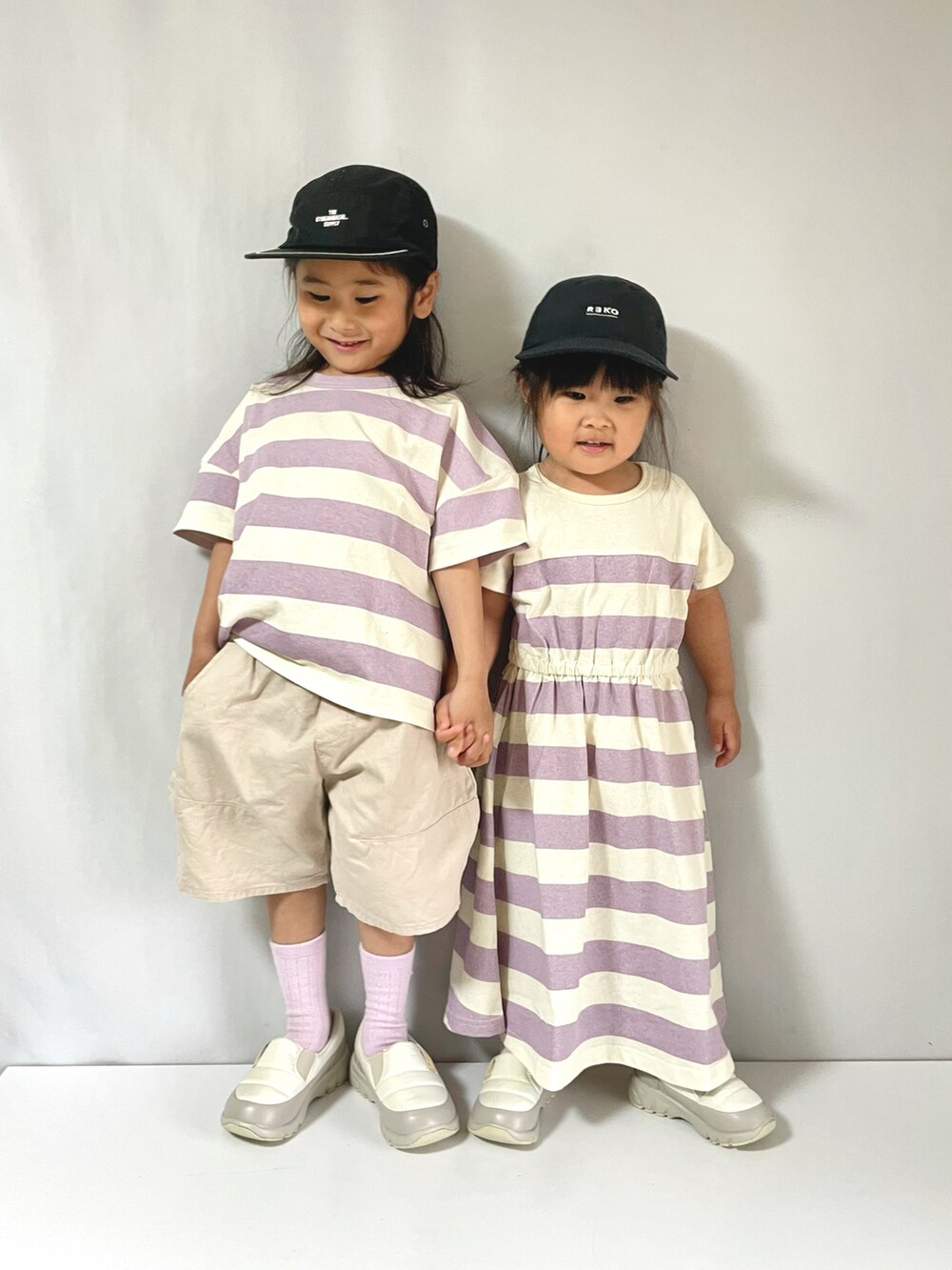 パープル系のTシャツ/カットソー、パープル系のワンピース、ホワイト系のシューズを着用したキッズの夏コーディネートの2枚目の写真