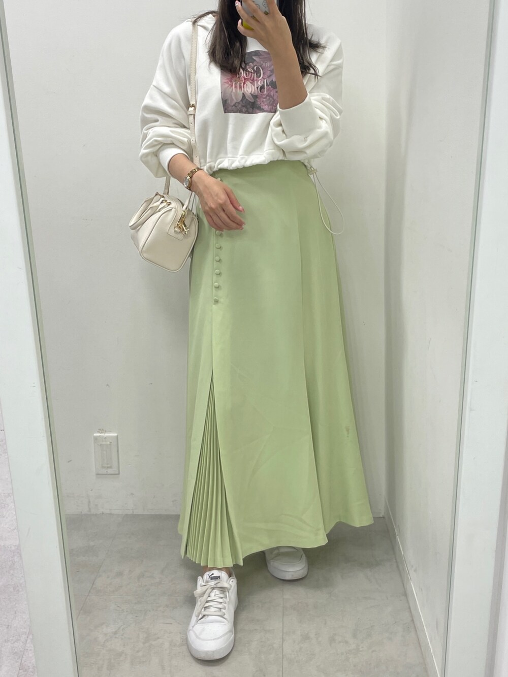 ホワイト系のダウンジャケット/コート、ホワイト系のスウェット、グリーン系のスカートを着用したレディースの秋コーディネートの4枚目の写真