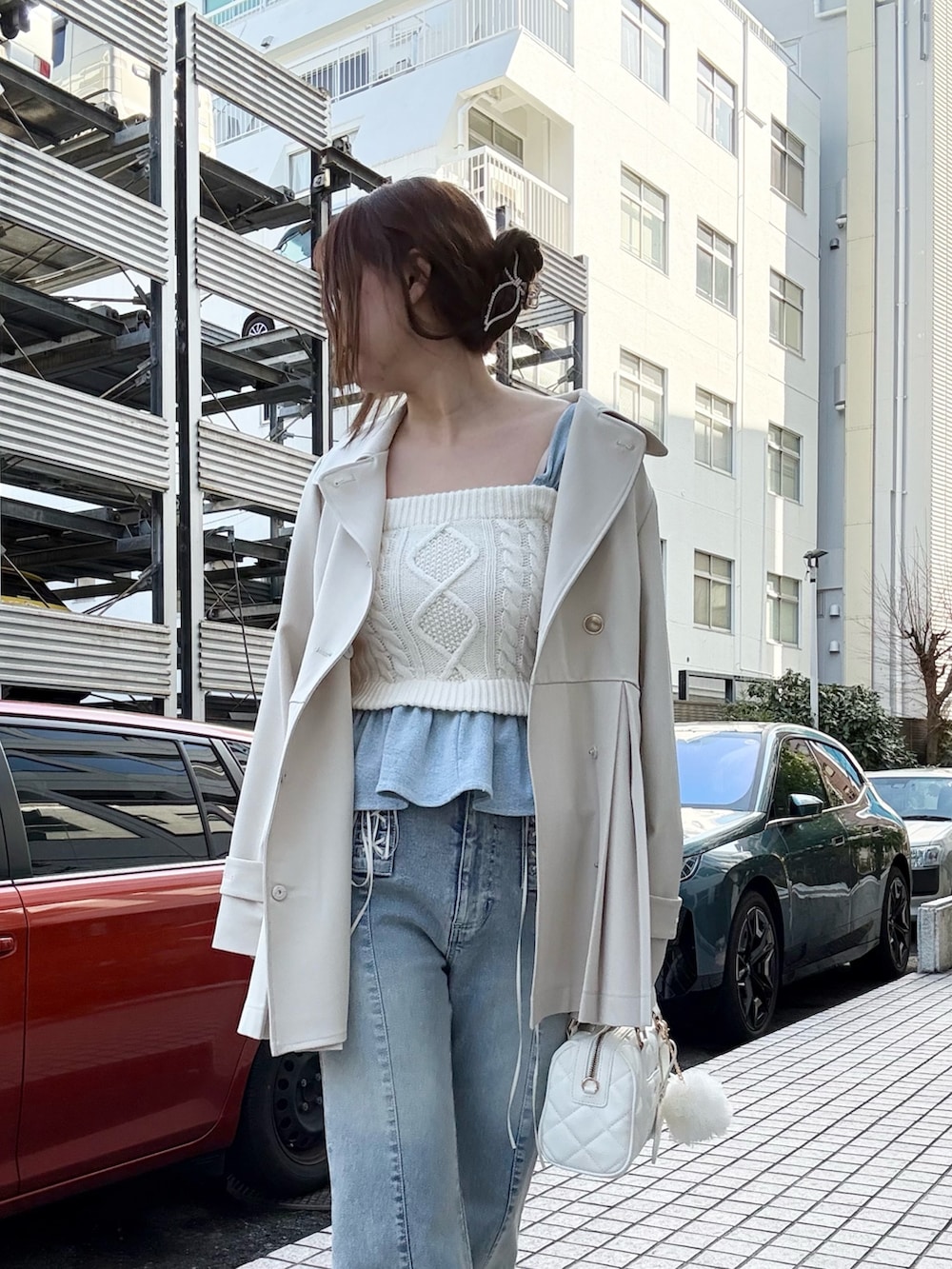 ホワイト系のトレンチコート、ホワイト系のその他トップス、ブルー系のデニムパンツを着用したレディースの冬コーディネートの4枚目の写真