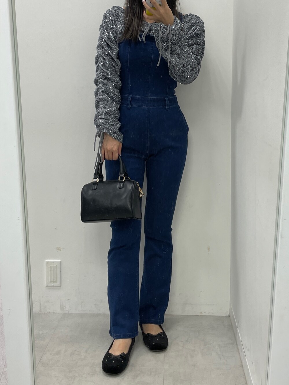 ブルー系のサロペット/オーバーオール、グレー系のシャツ/ブラウス、ブラック系のハンドバッグを着用したレディースの秋コーディネートの2枚目の写真