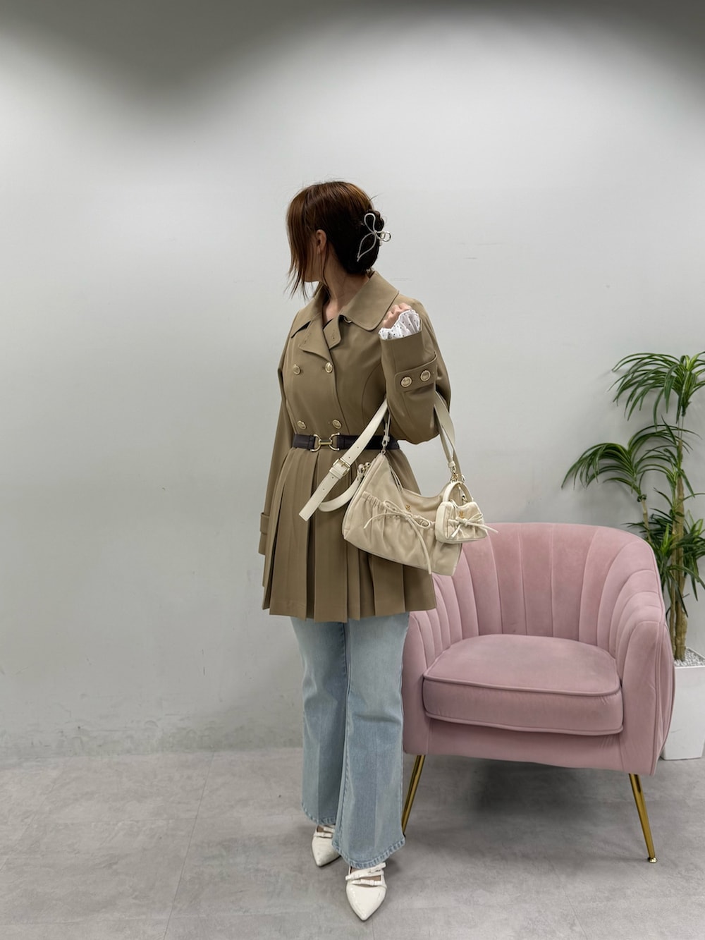 ベージュ系のトレンチコート、ホワイト系のショルダーバッグ、ホワイト系のパンプスを着用したレディースの春コーディネートの3枚目の写真