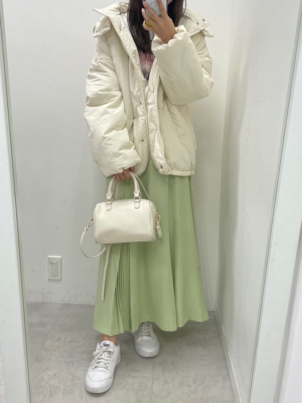 ホワイト系のダウンジャケット/コート、ホワイト系のスウェット、グリーン系のスカートを着用したレディースの秋コーディネートの2枚目の写真
