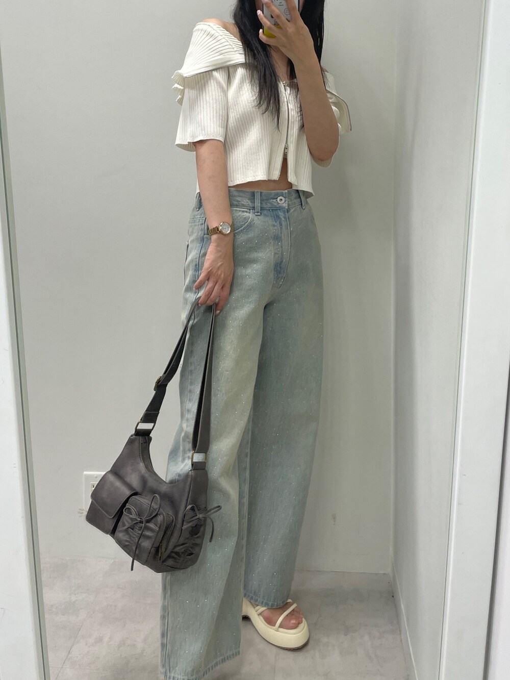 ホワイト系のニット/セーター、ブルー系のデニムパンツ、ブラック系のショルダーバッグを着用したレディースの夏コーディネートの4枚目の写真