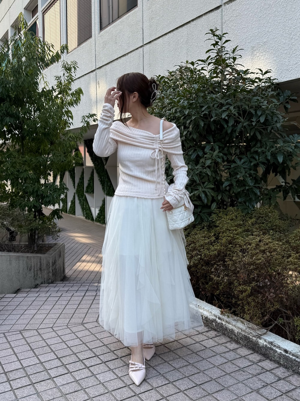 ピンク系のTシャツ/カットソー、ホワイト系のスカート、ホワイト系のショルダーバッグを着用したレディースの冬コーディネートの2枚目の写真