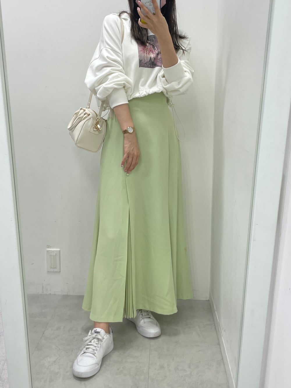 ホワイト系のダウンジャケット/コート、ホワイト系のスウェット、グリーン系のスカートを着用したレディースの秋コーディネートの3枚目の写真