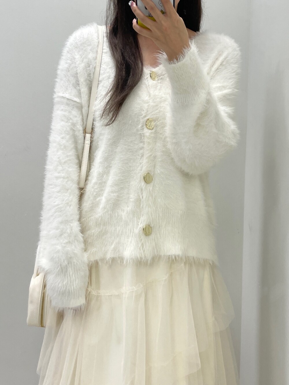 ホワイト系のカーディガン/ボレロ、ホワイト系のスカート、ホワイト系のボストンバッグを着用したレディースの秋コーディネートの3枚目の写真