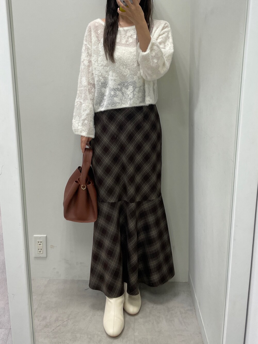 ホワイト系のニット/セーター、ブラウン系のスカート、ブラウン系のハンドバッグを着用したレディースの秋コーディネートの5枚目の写真