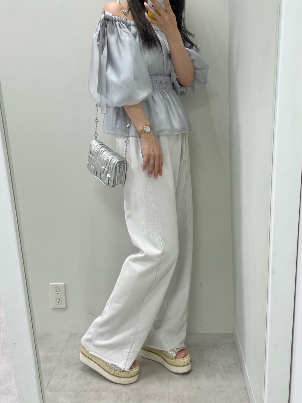 ブルー系のシャツ/ブラウス、グレー系のその他パンツ、シルバー系のショルダーバッグを着用したレディースの春コーディネートの2枚目の写真