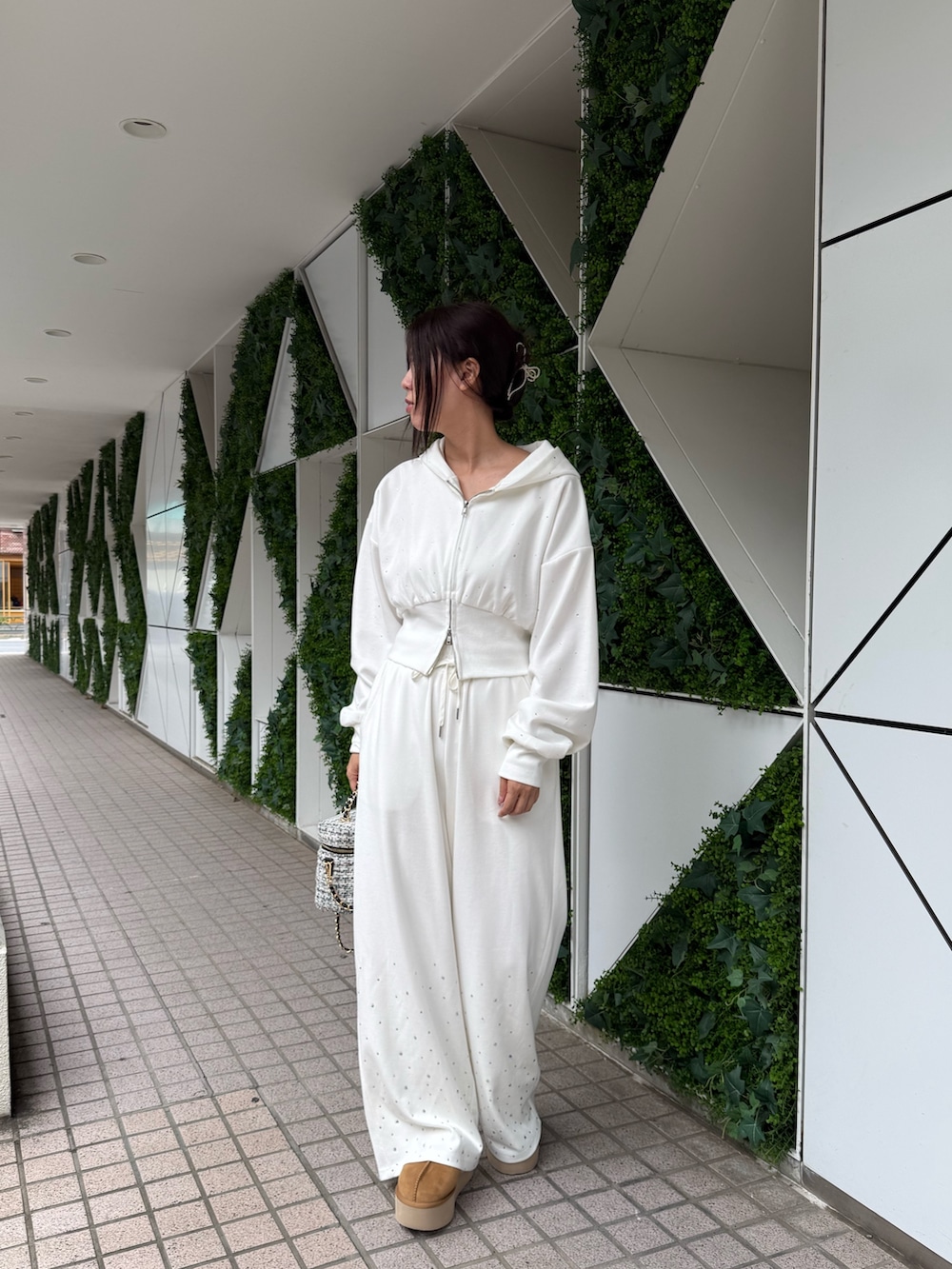 ホワイト系のパーカー、ホワイト系のスウェットパンツ、イエロー系のサンダルを着用したレディースの秋コーディネートの2枚目の写真