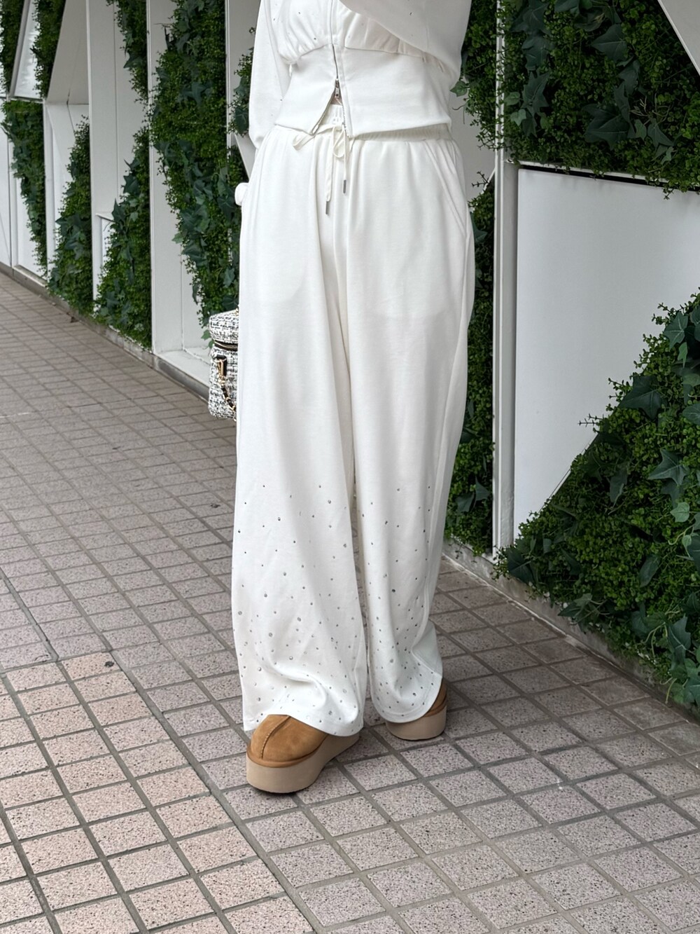 ホワイト系のパーカー、ホワイト系のスウェットパンツ、イエロー系のサンダルを着用したレディースの秋コーディネートの4枚目の写真